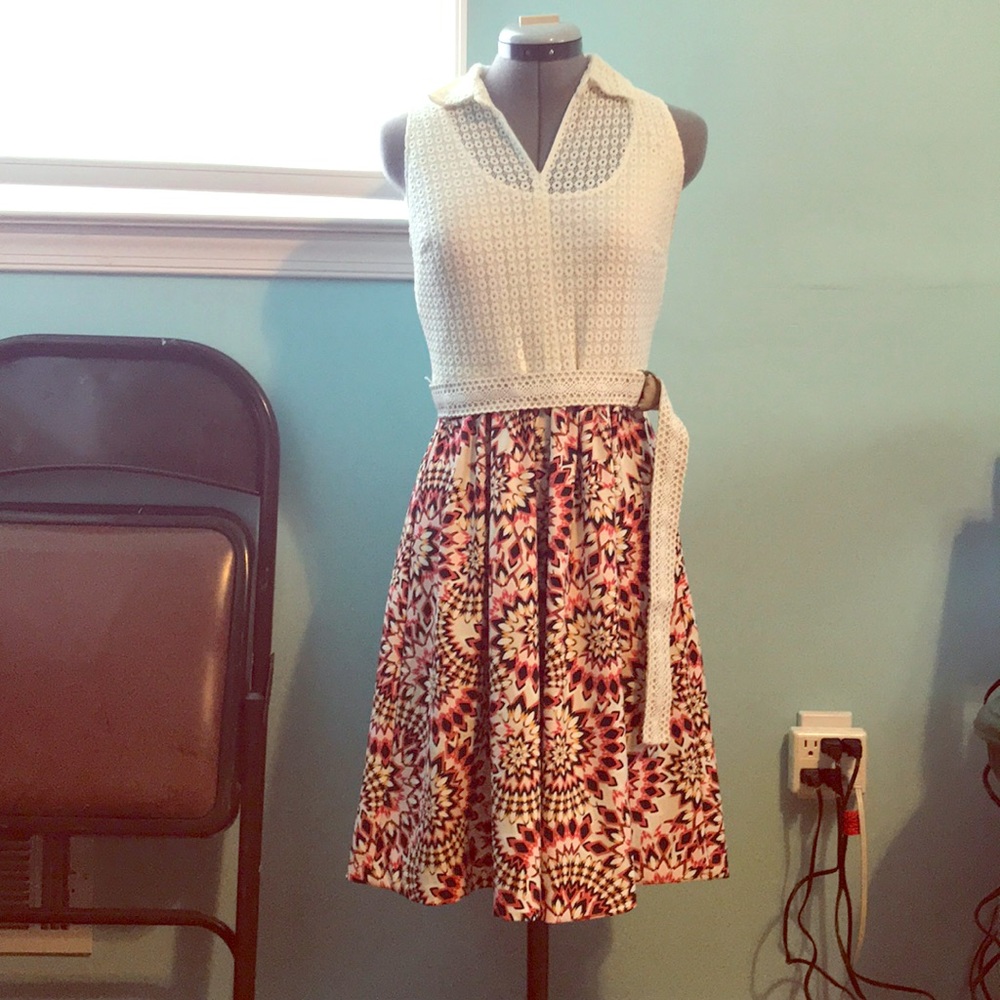 Sleeveless dress with collar and belt.